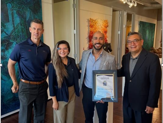 Moises Solis and Scott Creger presenting a leadership certificate to a graduate